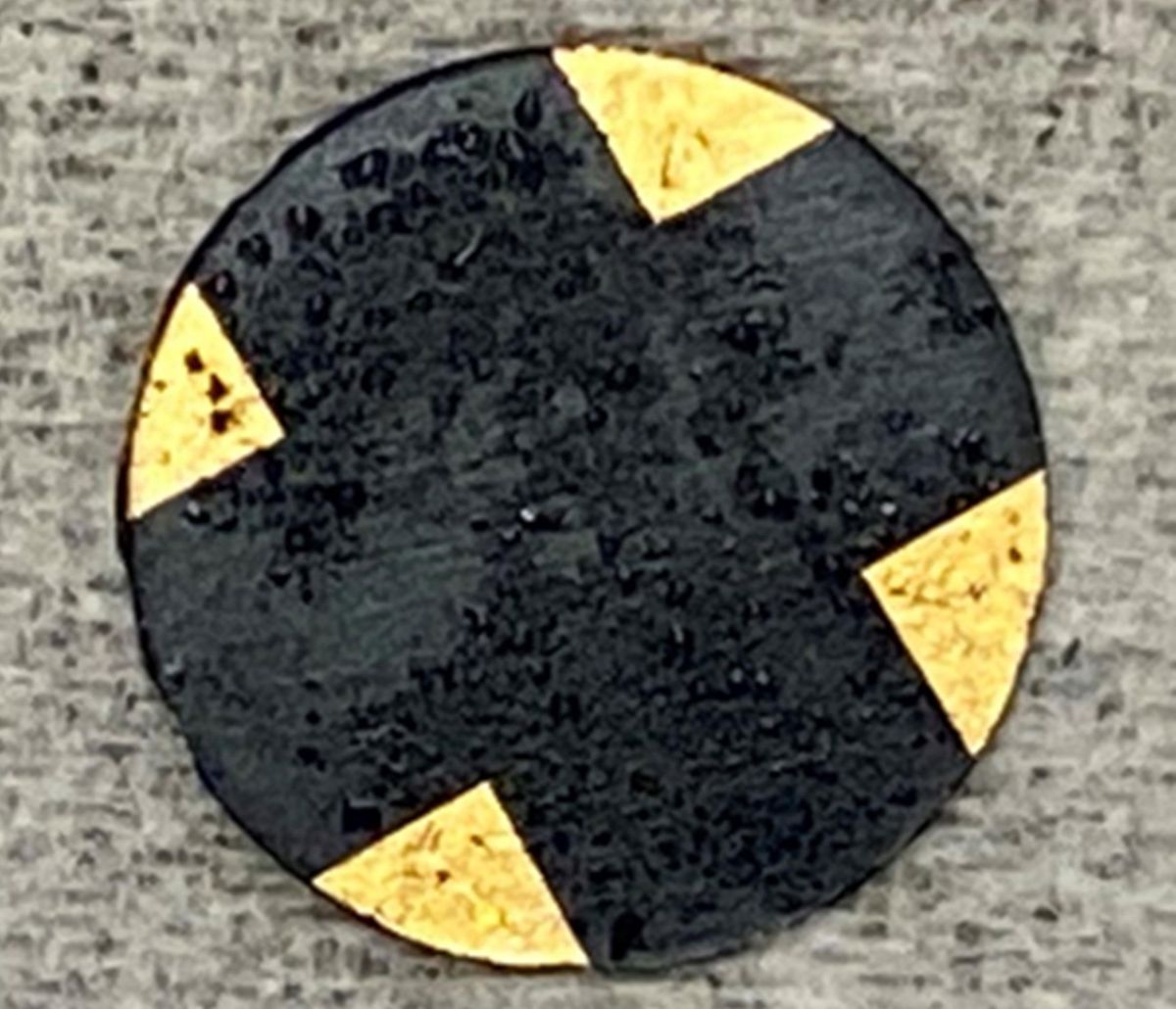 一个黑色的圆盘，在灰色的背景下，角上有金色的节点