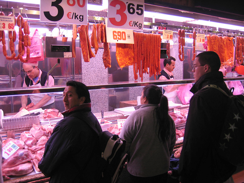 一张三个人站在肉类柜台前的照片。