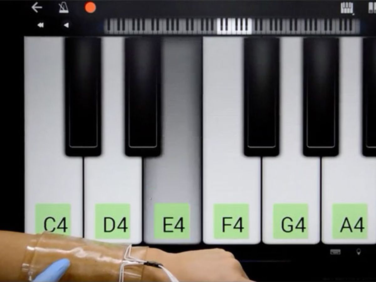 用前臂上的可拉伸触控板弹奏虚拟钢琴。